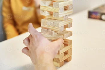 17007801-jogo-de-tabuleiro-em-familia-as-maos-pegam-o-bloco-de-madeira-da-torre-foto